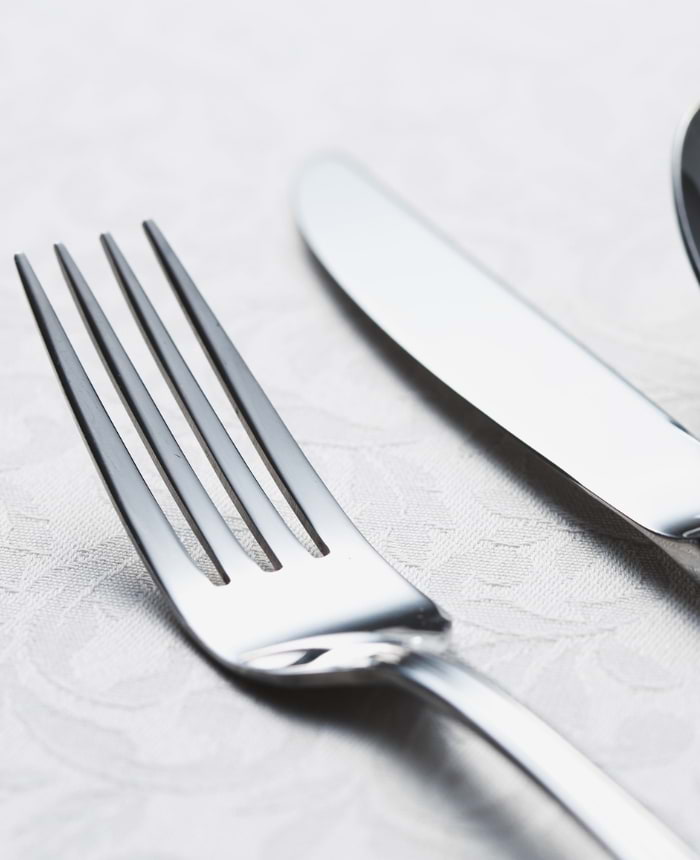 Conjunto de talheres em prata sobre toalha de mesa branca – prataria clássica à venda em São Paulo