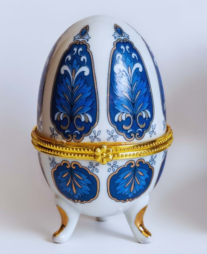 Ovo decorativo de porcelana com detalhes azuis e dourados